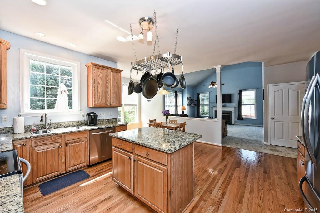 4719 Lapis Court Fort Mill, SC 29708 - Photo 2 of 24 a kitchen with stainless steel appliances granite countertop a sink dishwasher and wooden cabinets with wooden floor