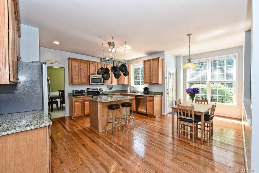 4719 Lapis Court Fort Mill, SC 29708 - Photo 7 of 24 a kitchen with stainless steel appliances kitchen island granite countertop dining table chairs and granite counter top