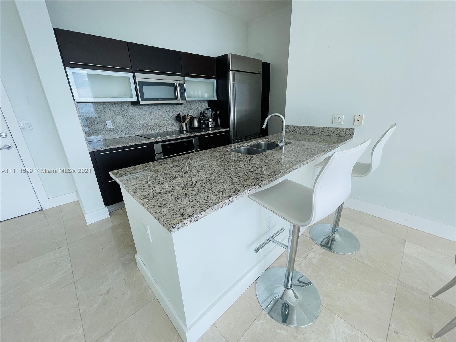 a kitchen with kitchen island a sink stainless steel appliances and a counter top
