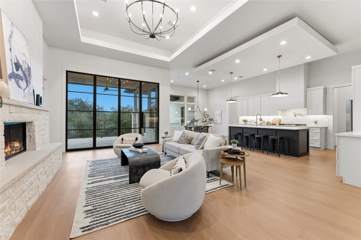 a living room with furniture kitchen view and a large window