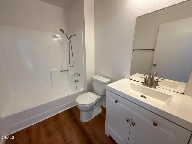 a bathroom with a sink mirror vanity and toilet