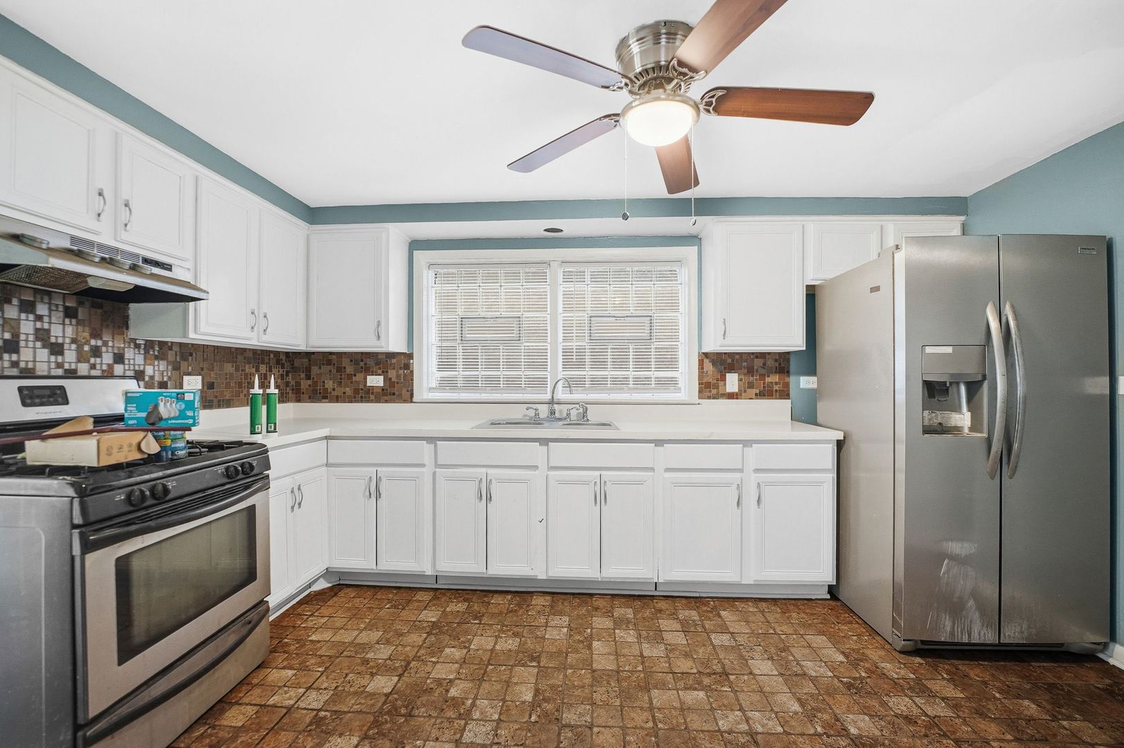 9209 South State Street Chicago, IL 60619 - Photo 17 of 20 a kitchen with white cabinets a sink a stove a refrigerator and a stove