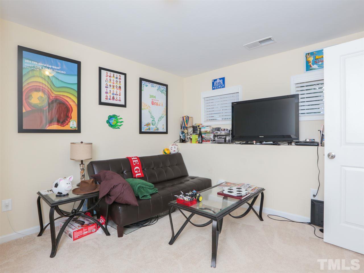 1543 Crafton Way Raleigh, NC 27607 - Photo 18 of 25 a living room with furniture and a flat screen tv