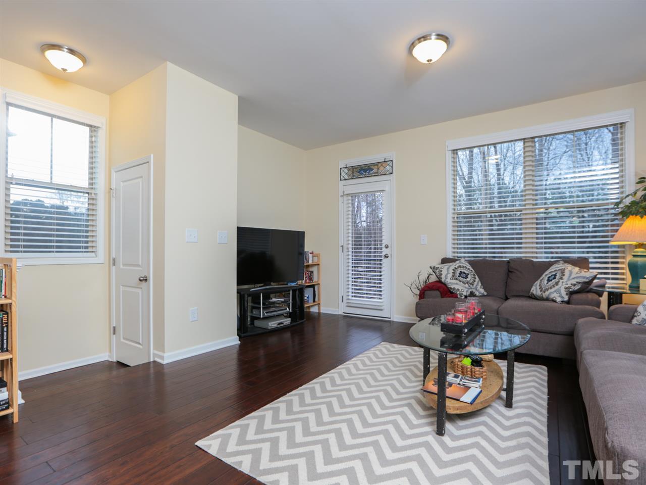 1543 Crafton Way Raleigh, NC 27607 - Photo 4 of 25 a living room with furniture and a flat screen tv with wooden floor