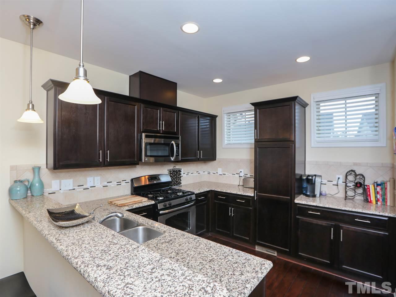 1543 Crafton Way Raleigh, NC 27607 - Photo 9 of 25 a kitchen with granite countertop stainless steel appliances a stove sink microwave and cabinets