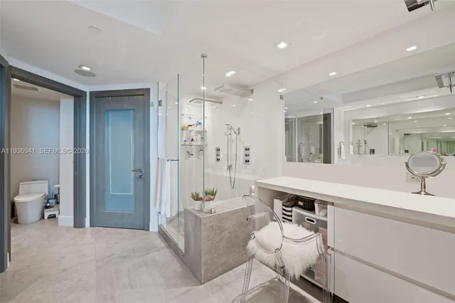 a spacious bathroom with a sink a toilet a mirror and shower