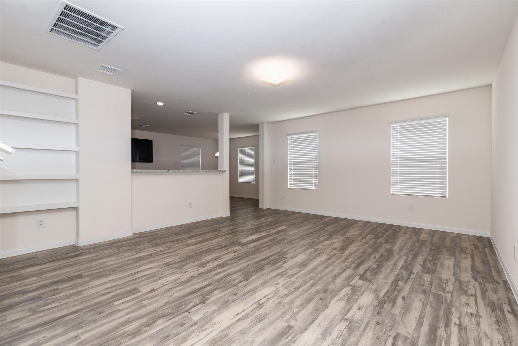 24322 Amaldi Court Katy, TX 77493 - Photo 2 of 8 an empty room with wooden floor and windows