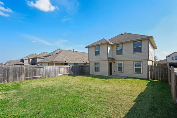 a view of a house with a big yard and large tree
