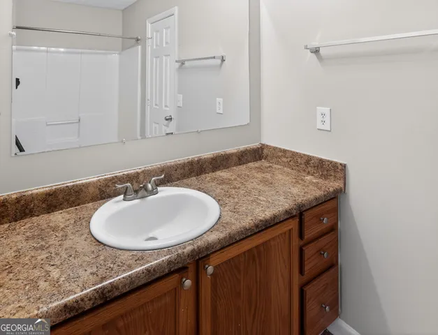 a bathroom with a granite countertop sink and a mirror