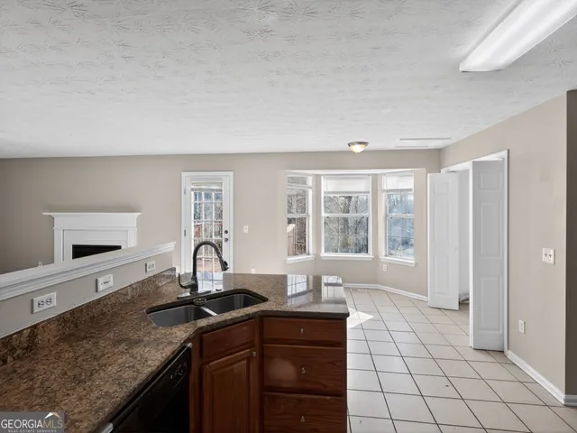 a kitchen with granite countertop a sink stove and cabinets