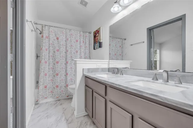 a bathroom with a granite countertop sink a mirror a vanity and a shower