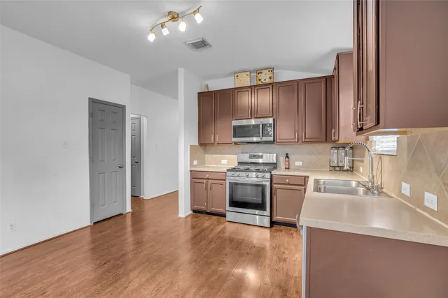 a kitchen with a sink stainless steel appliances and cabinets