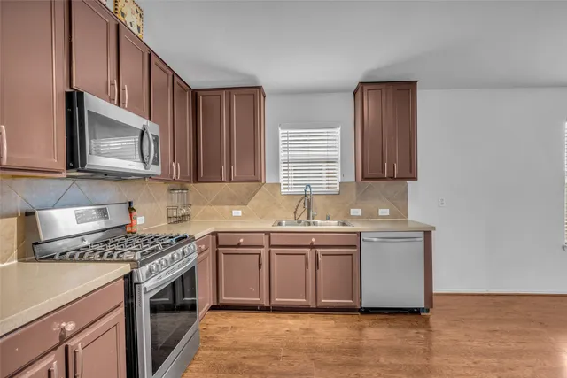 a kitchen with stainless steel appliances granite countertop a sink stove and microwave