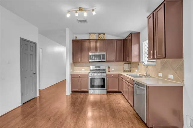 a kitchen with a sink cabinets and stainless steel appliances