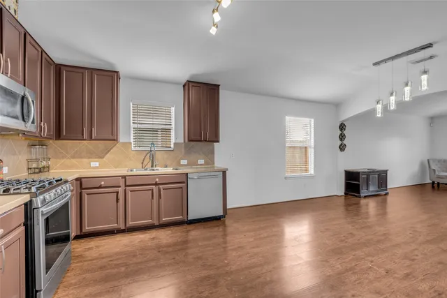 a kitchen with stainless steel appliances granite countertop a sink cabinets stove and oven