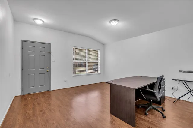 a view of a workspace with furniture and a window