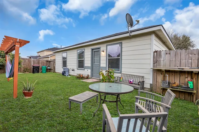 a view of a house with backyard and sitting area