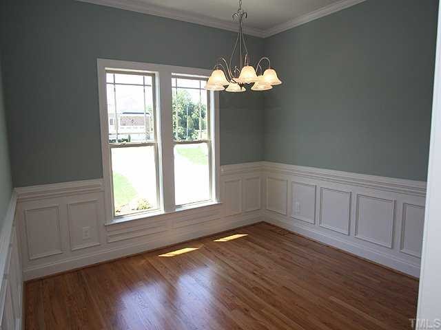 1313 Silver Farm Road Raleigh, NC 27603 - Photo 3 of 12 an empty room with wooden floor and windows