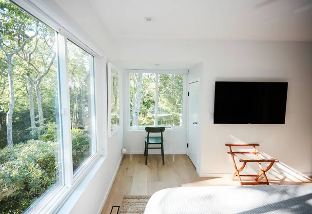 a living room with a large window and a flat tv screen next to a large window