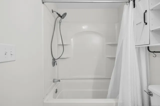 a bathroom with a bath tub with a shower