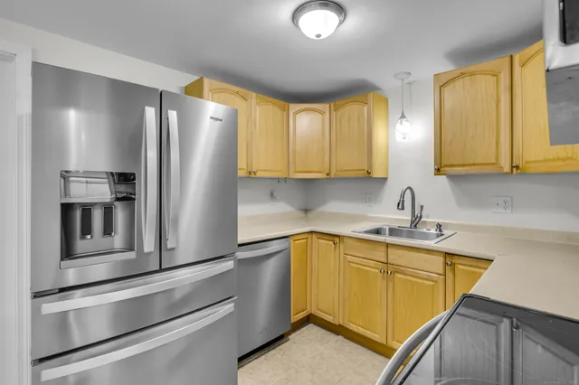 a kitchen with stainless steel appliances granite countertop a refrigerator a stove and a sink