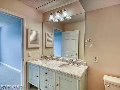 109 Wading Bird Circle, Unit V102 Naples, FL 34110 - Photo 12 of 15 a bathroom with a granite countertop sink a toilet and a mirror