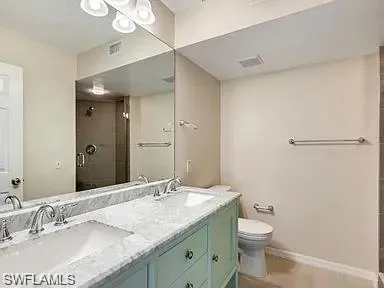 a bathroom with a granite countertop sink a toilet and a mirror