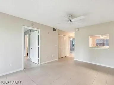 a view of an empty room with a ceiling fan