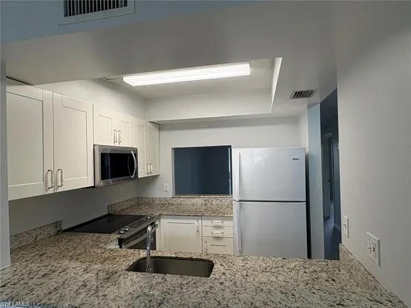 a kitchen with a refrigerator and a stove top oven