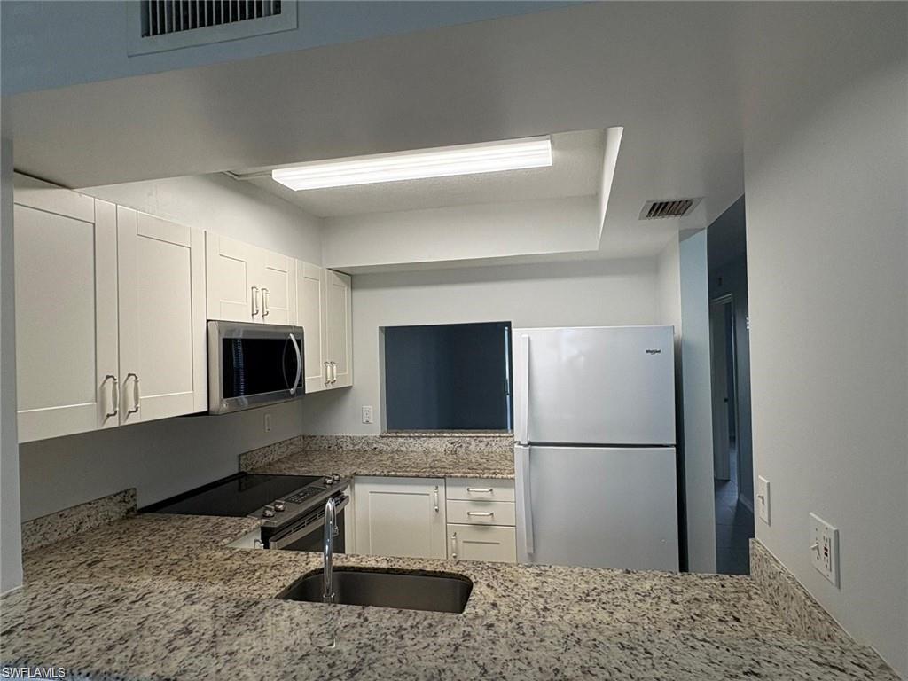 109 Wading Bird Circle, Unit V102 Naples, FL 34110 - Photo 7 of 15 a kitchen with a refrigerator and a stove top oven