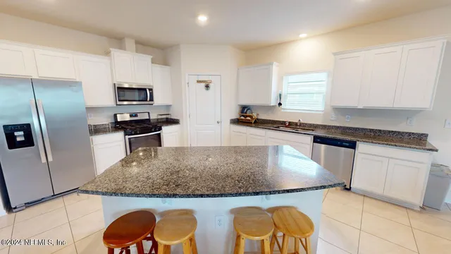 a kitchen with stainless steel appliances granite countertop a sink a stove and refrigerator