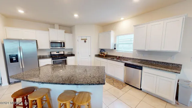 a kitchen with stainless steel appliances granite countertop a sink a stove and a refrigerator