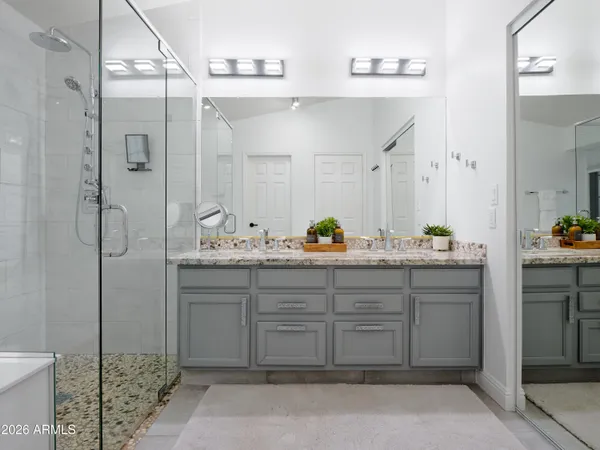 a bathroom with a double vanity sink toilet mirror and shower