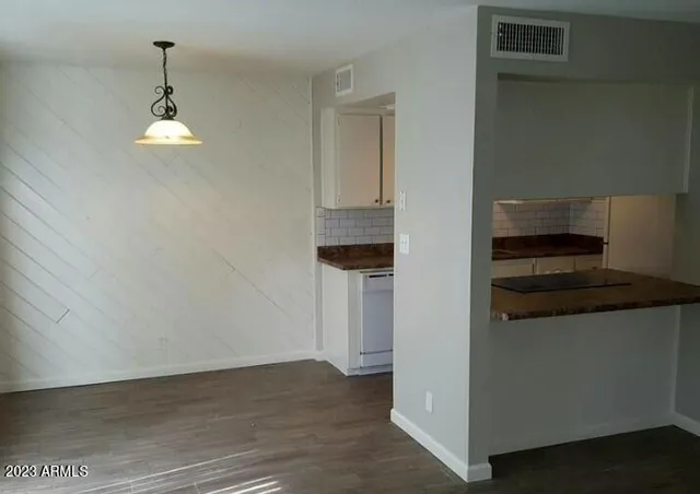 an empty room with wooden floor cabinets and a ceiling fan