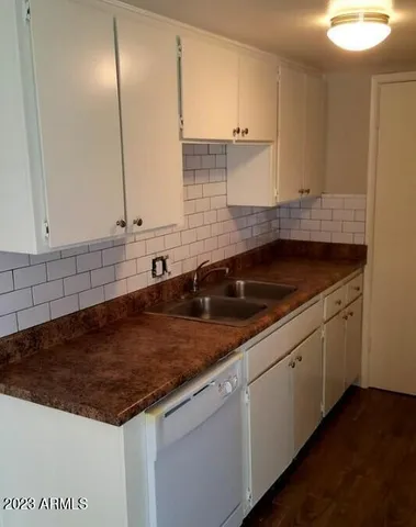 a kitchen with granite countertop a sink and cabinets