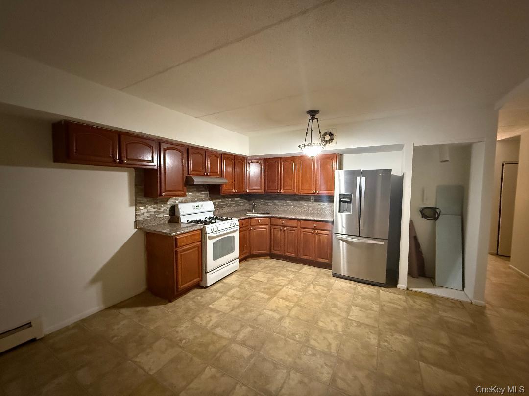 827 Longfellow Avenue Bronx, NY 10474 - Photo 4 of 16 a kitchen with stainless steel appliances kitchen island granite countertop a refrigerator a sink a stove a microwave oven with cabinets