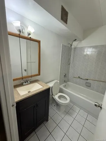 a bathroom with a double vanity sink a toilet a mirror and shower