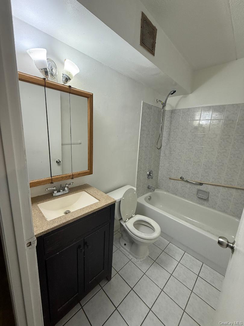 827 Longfellow Avenue Bronx, NY 10474 - Photo 6 of 16 a bathroom with a double vanity sink a toilet a mirror and shower