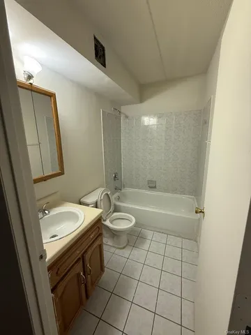 a bathroom with a granite countertop sink a toilet a mirror and shower