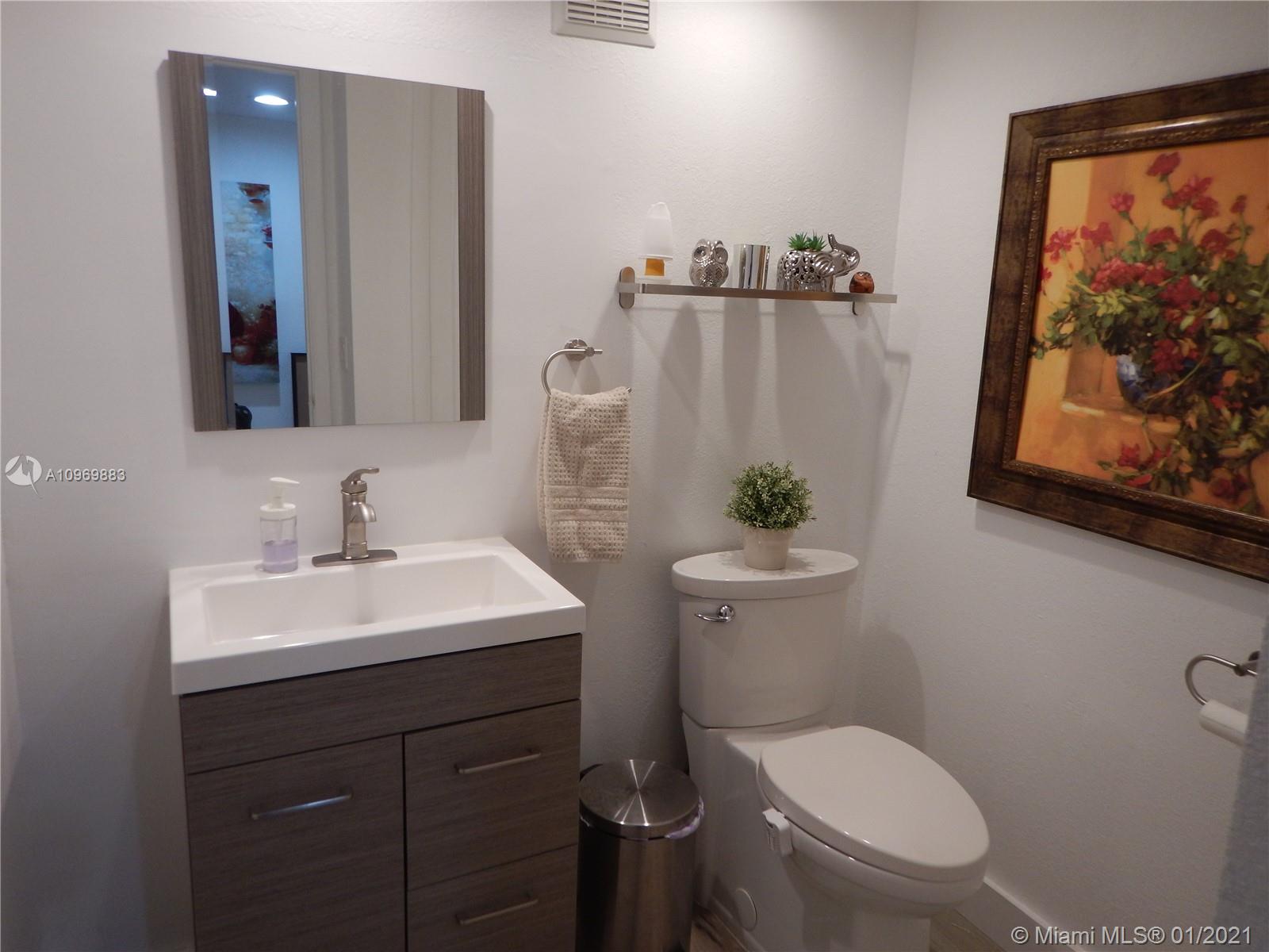 16100 Golf Club Road, Unit 210 Weston, FL 33326 - Photo 2 of 40 a bathroom with a toilet sink and mirror