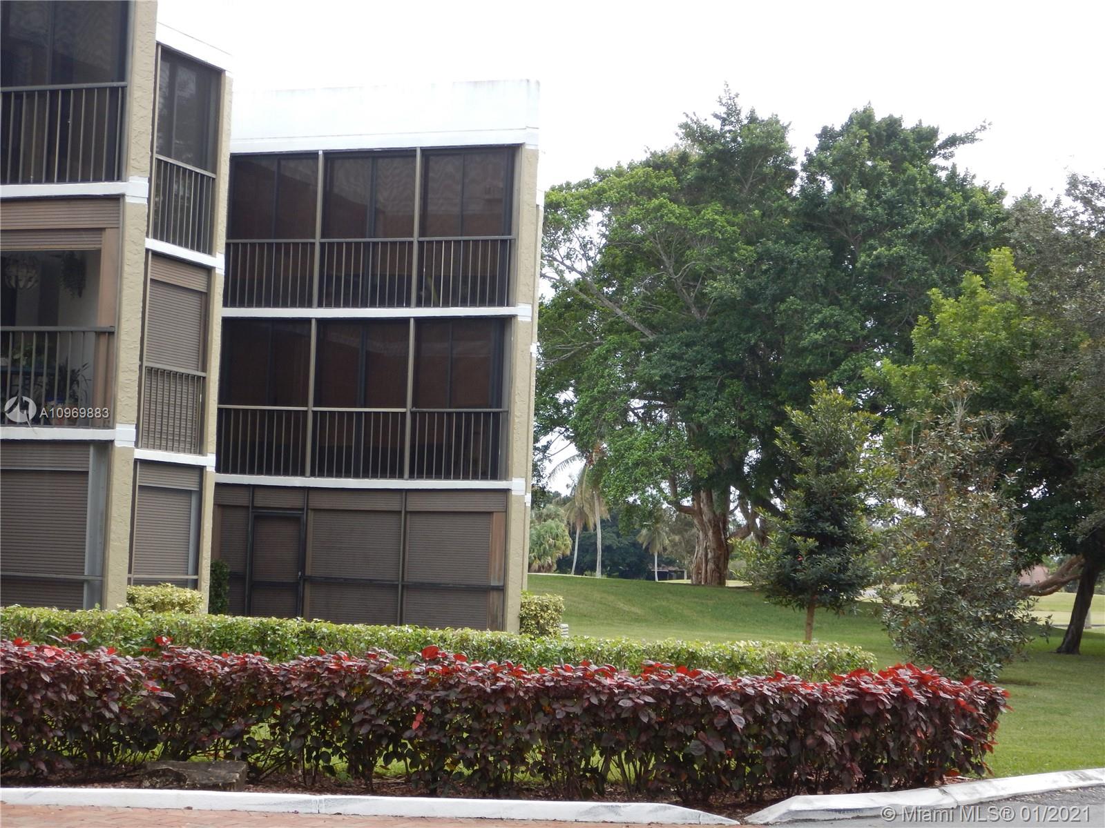 16100 Golf Club Road, Unit 210 Weston, FL 33326 - Photo 14 of 40 a view of a house with a yard and large trees