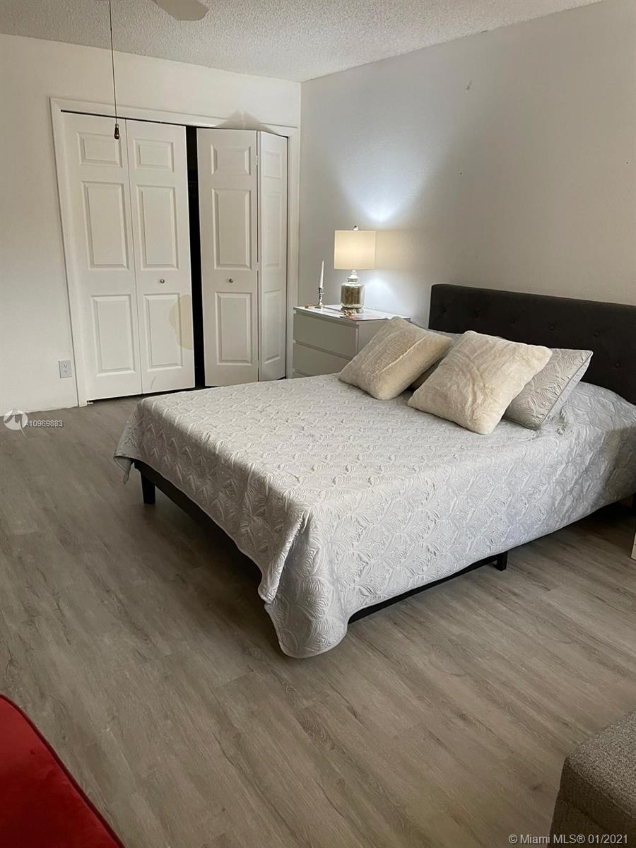 16100 Golf Club Road, Unit 210 Weston, FL 33326 - Photo 16 of 40 a spacious bedroom with a bed and a cabinets