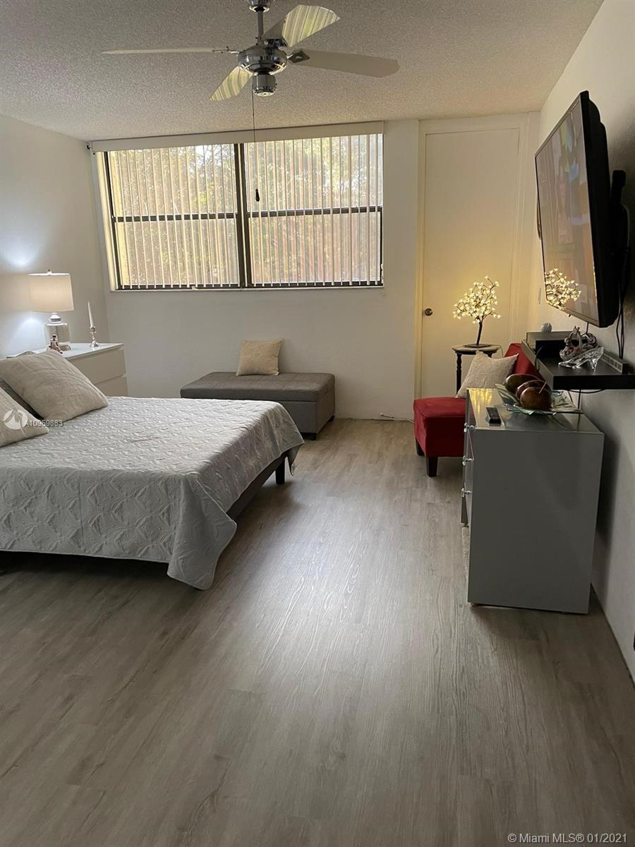 16100 Golf Club Road, Unit 210 Weston, FL 33326 - Photo 18 of 40 a bedroom with bed tv and window