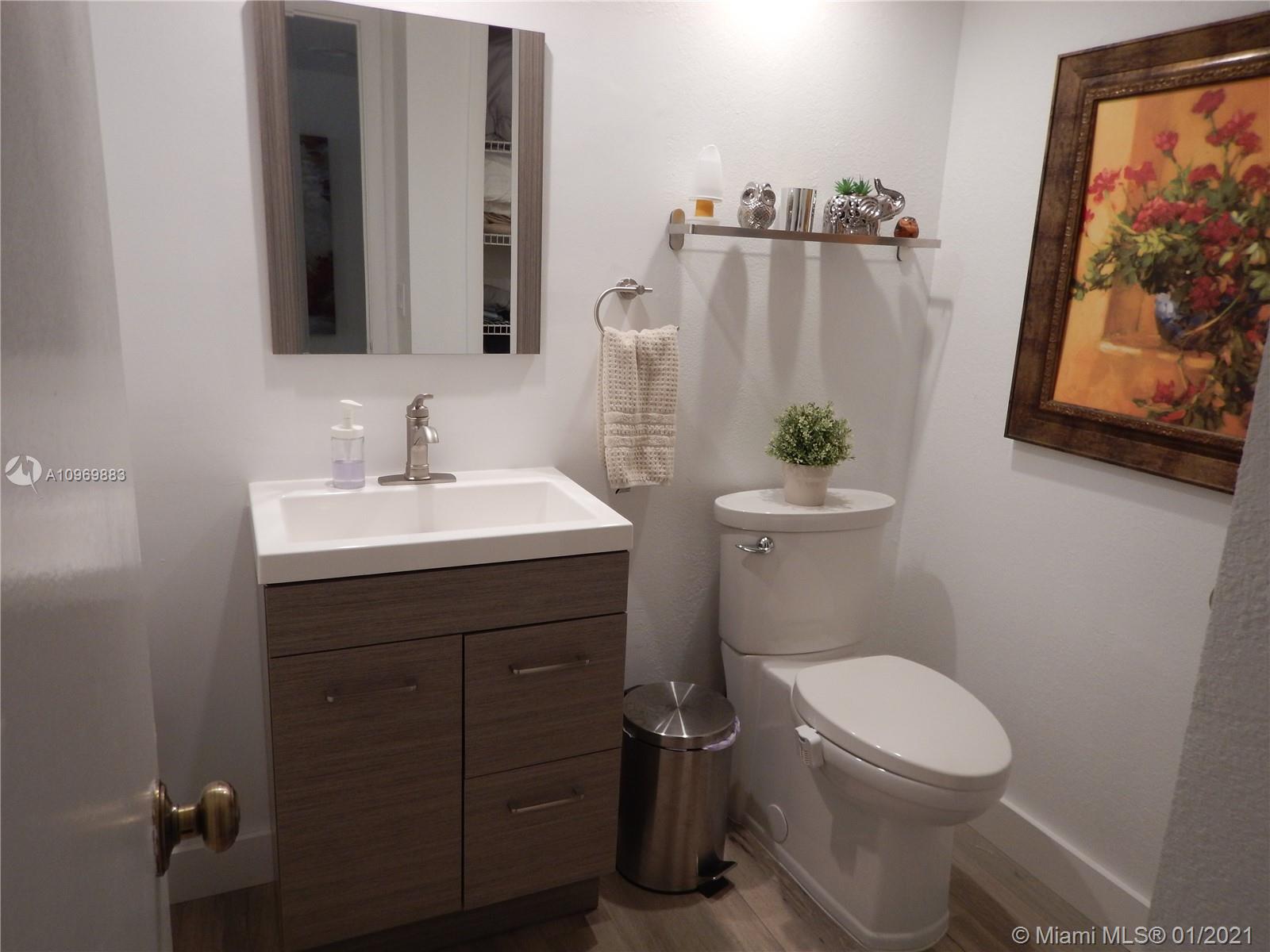 16100 Golf Club Road, Unit 210 Weston, FL 33326 - Photo 3 of 40 a bathroom with a toilet a sink and mirror