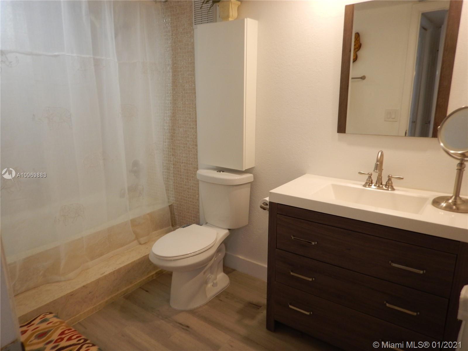 16100 Golf Club Road, Unit 210 Weston, FL 33326 - Photo 22 of 40 a bathroom with a sink toilet and a mirror