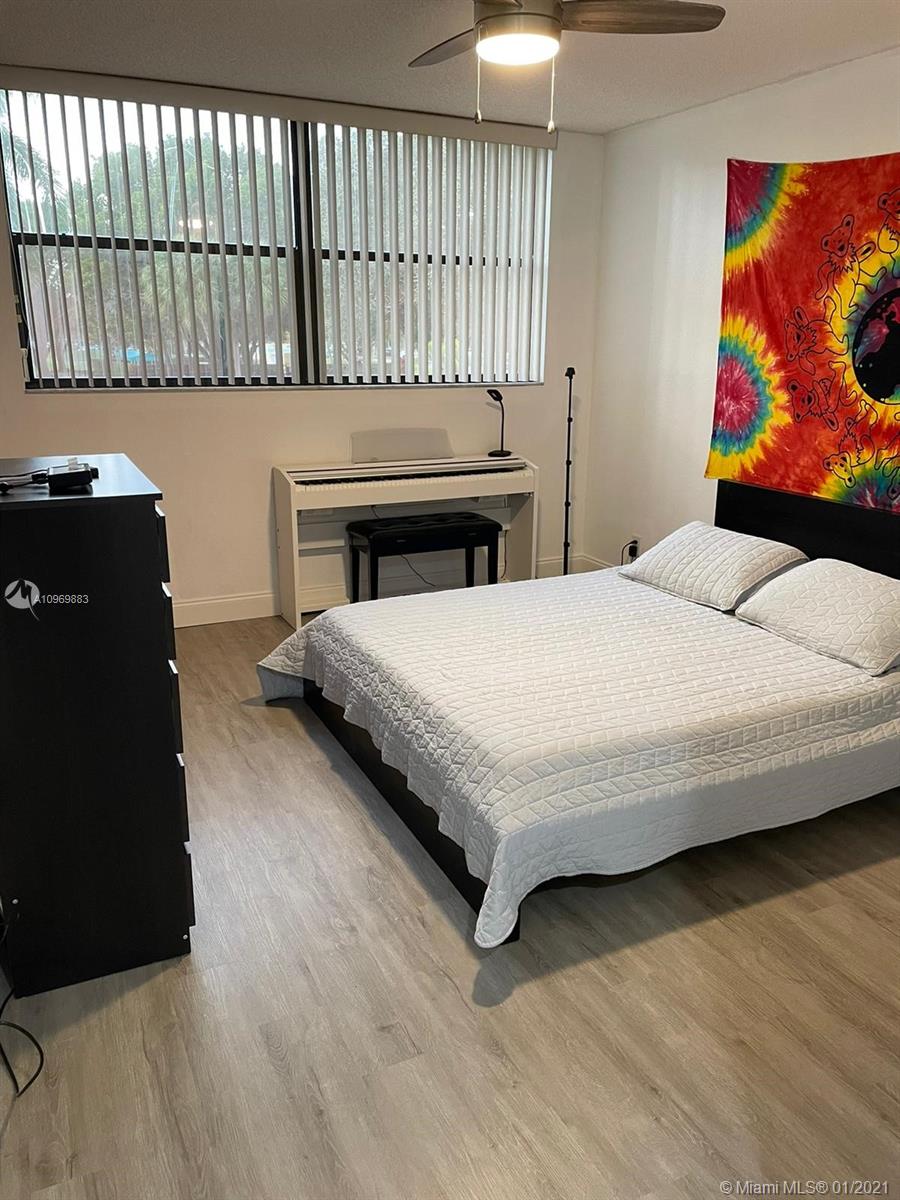 16100 Golf Club Road, Unit 210 Weston, FL 33326 - Photo 24 of 40 a bedroom with a bed and a wall painting