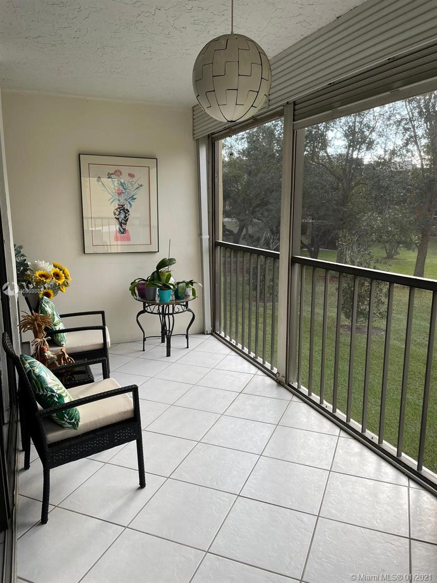 16100 Golf Club Road, Unit 210 Weston, FL 33326 - Photo 27 of 40 a living room with furniture a flat screen tv and a large window