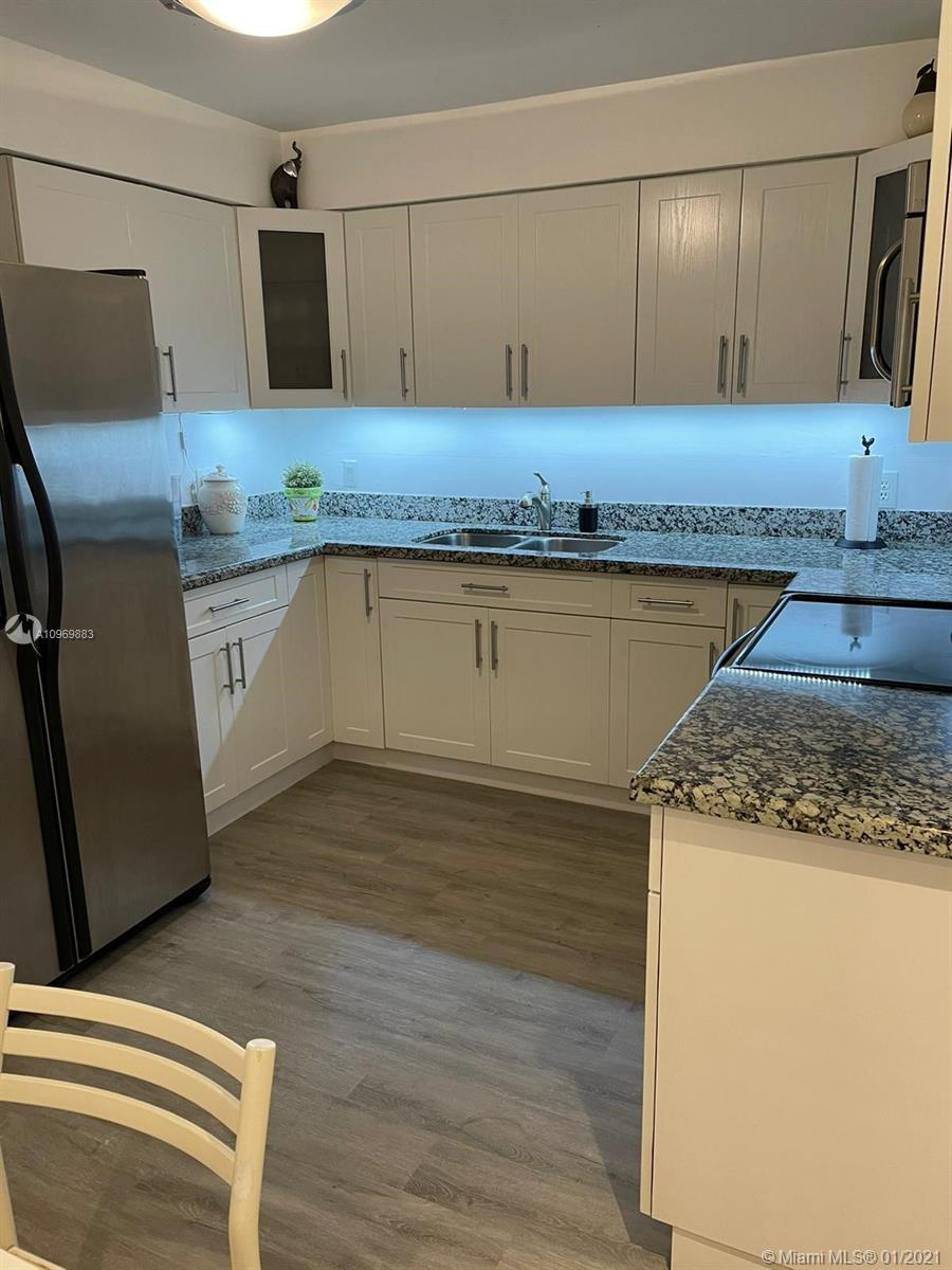 16100 Golf Club Road, Unit 210 Weston, FL 33326 - Photo 31 of 40 a kitchen with granite countertop a sink a stove and cabinets