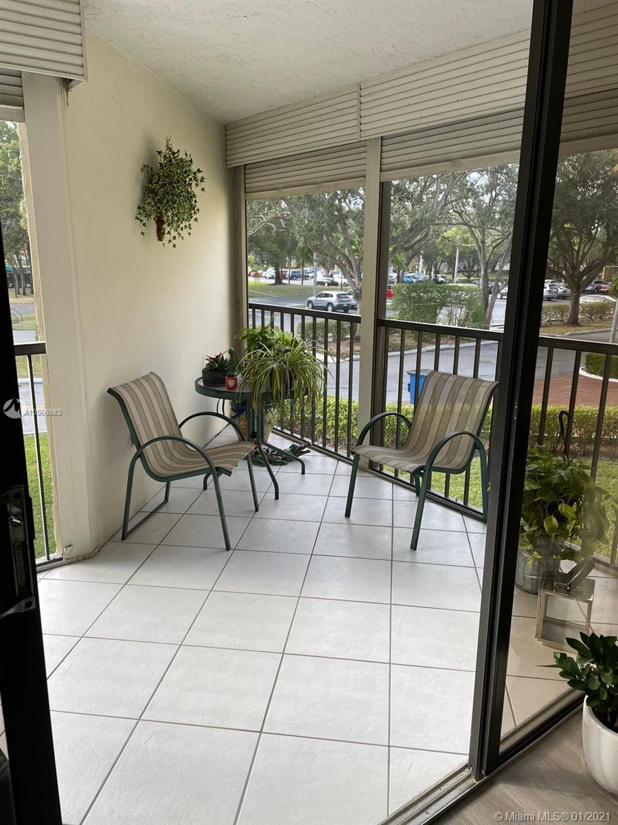 16100 Golf Club Road, Unit 210 Weston, FL 33326 - Photo 33 of 40 a living room with furniture and a floor to ceiling window