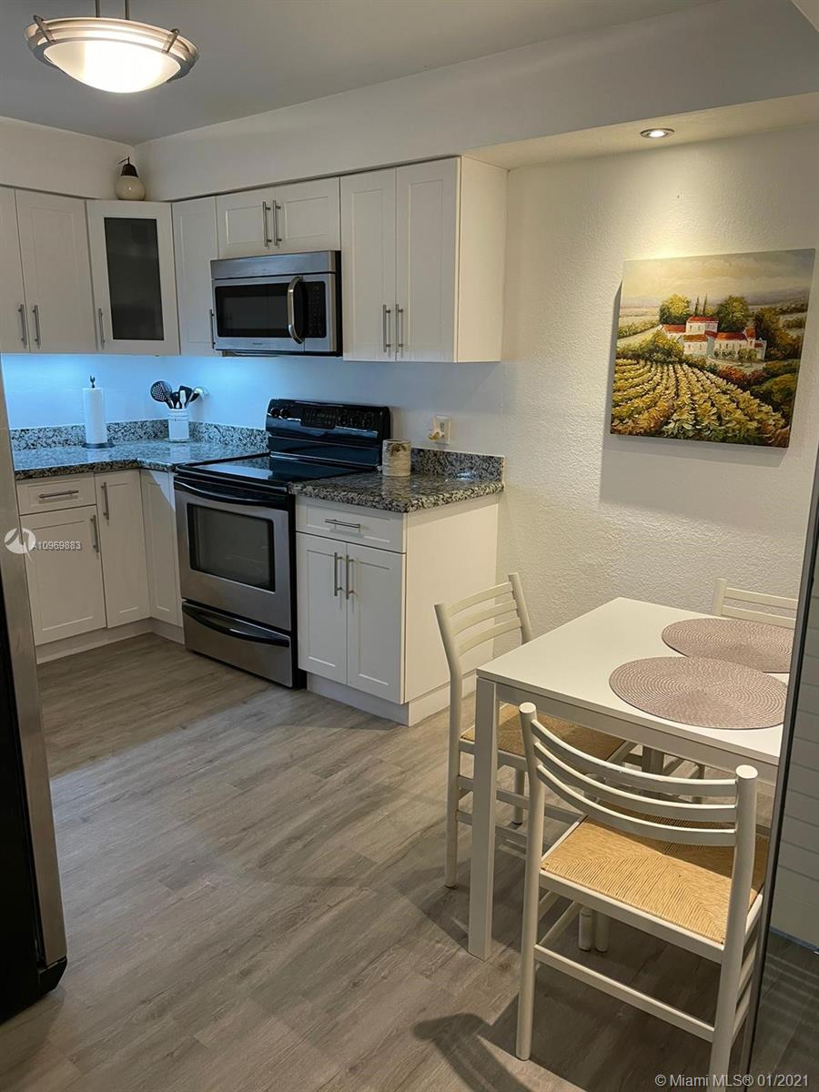 16100 Golf Club Road, Unit 210 Weston, FL 33326 - Photo 5 of 40 a kitchen with a stove and a microwave